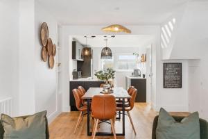 a kitchen and dining room with a table and chairs at Stylish & Modern Home, Central Newquay w/parking in Newquay