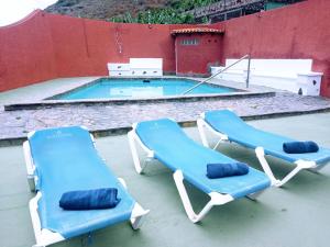 2 blaue Liegestühle und ein Pool in der Unterkunft Live Garachico Villa Daute con terraza y piscina in Las Cruces