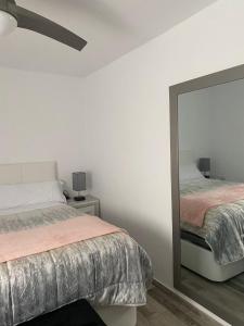 a bedroom with two beds and a mirror at Tarifabeach in Tarifa