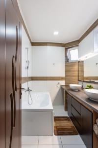 baño con bañera blanca y 2 lavabos en Rosé Apartments, en Bogács