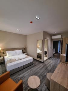 1 dormitorio con 1 cama grande y sala de estar en Hotel Kalfa, en Trabzon