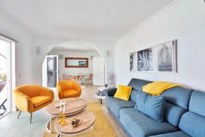 sala de estar con sofá azul y sillas de color naranja en Villa Nirvana - Casa Marosenia, en Güime