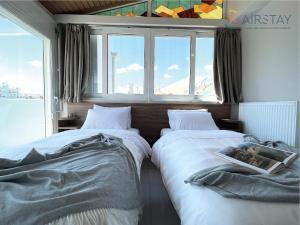 two beds in a room with a window at Akali Apartment airport by Airstay in Spata