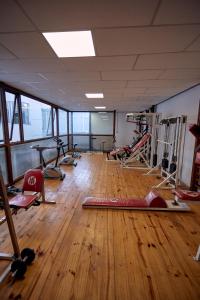 a gym with lots of exercise equipment on a wooden floor at San Martin Hotel y Spa in San Rafael