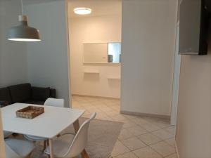 jadalnia z białym stołem i krzesłami w obiekcie Gardasee apartment w mieście Riva del Garda