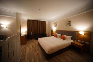 una camera d'albergo con un grande letto con due cuscini arancioni di Mado Hotel ad Addis Abeba