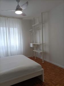 sypialnia z łóżkiem i wentylatorem sufitowym w obiekcie Gardasee apartment w mieście Riva del Garda