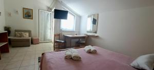um quarto com uma cama com um par de sapatos em Studio apartman Olivera em Rovinj