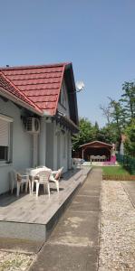 a house with a wooden deck with a table and chairs at 4 Lurkó Apartman Új in Hajdúszoboszló