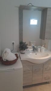 y baño con lavabo y espejo. en Cosy Studio for couples 2 min from Mades Beach, en Ligaria