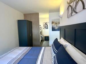 a bedroom with a large bed with a blue headboard at Apartment 3 Benllech with Sea views in Benllech