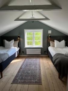 a attic bedroom with two beds and a window at Annexet Orrabackens in Järvsö