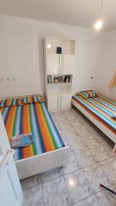 two beds in a room with colorful sheets at Vasiliki's guest house in Vergia