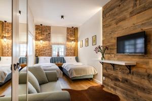 a bedroom with two beds and a tv on a wall at Gotyk House in Gdańsk
