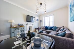 a living room with a couch and a table at Flat 3 Flint House Tenby - Luxury couples apartment in Tenby