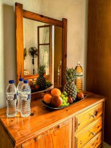 un tocador de madera con frutas y botellas de agua. en Katerina's Apartments, en Agios Stefanos