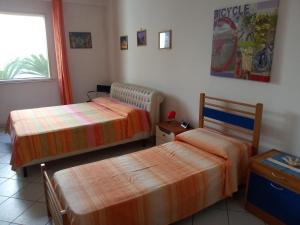 1 dormitorio con 2 camas y ventana en Matino Casa Vacanza, en Matino