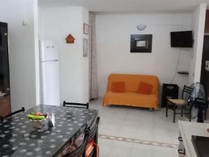 a kitchen with an orange couch in a room at Sole, Mare e Relax a Matino La Tua Oasi Salentina in Matino