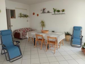 - une salle à manger avec une table et deux chaises bleues dans l'établissement Matino Casa Vacanza, à Matino