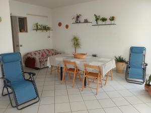a dining room with a table and two blue chairs at Sole, Mare e Relax a Matino La Tua Oasi Salentina in Matino
