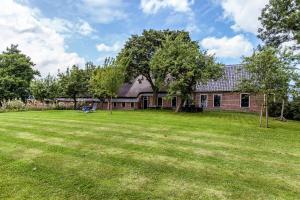 een huis met een grote tuin ervoor bij B&B Oldenbosch in Holwierde