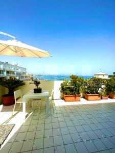 a white table and chairs on a patio with the beach at La mia terrazza sul mare - Mared'aMare in Bari