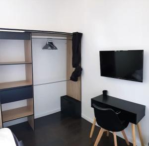 um quarto com uma secretária e uma televisão na parede em Villeurbanne 100 m2 Superbe appartement 3 Chambres, 3 salle de bains em Villeurbanne