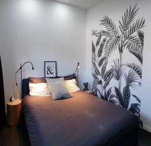 um quarto com uma cama grande e papel de parede tropical em Villeurbanne 100 m2 Superbe appartement 3 Chambres, 3 salle de bains em Villeurbanne