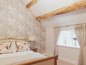a bedroom with a bed and a window at Stag Cottage in Macclesfield