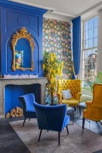 a living room with blue walls and a gold mirror at Hotel des Arts in Amsterdam