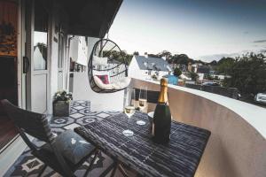 Una botella de vino sentada en una mesa en un balcón en Stoke Fleming Studio Apartment en Stoke Fleming