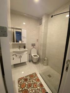 y baño con aseo, lavabo y ducha. en miamia apart otel en Bostancı
