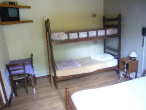 a bedroom with two bunk beds and a table and chair at Le Relais du Lac in Le Lauzet-Ubaye