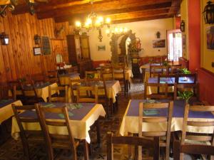 un restaurante con mesas y sillas y una lámpara de araña en Le Relais du Lac, en Le Lauzet-Ubaye