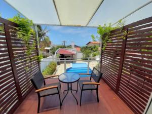 a patio with a table and chairs on a balcony at Innsenso B&B in Natal