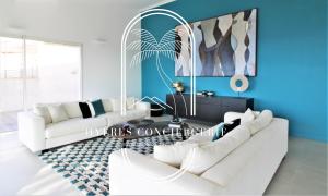 - un salon avec deux canapés blancs et un mur bleu dans l'établissement Grand Standing-Villa-Piscine rénovée Climatisée 4 chambres - vue mer époustouflante Parking-WIFI BY HC, à Hyères