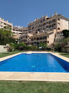 una gran piscina frente a un gran edificio en Encantador Piso con Terraza y Piscina, en Benalmádena