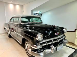 an old black and silver car parked in a room at Hotel Bons Tempos in Rio Verde