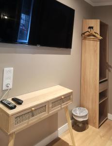 a room with a table with a tv on a wall at Hotel Hippodrome in Paris