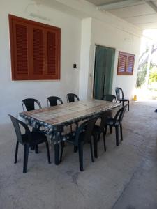 una mesa grande y sillas en una habitación en Pergola, en Matino