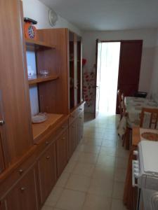 a large kitchen with wooden cabinets and a table at Pergola in Matino