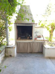 un horno de pizza al aire libre con una mesa en un patio en Pergola, en Matino