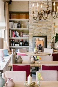 a restaurant with tables and chairs and a fireplace at Landhotel Heuvelzicht in Schin op Geul