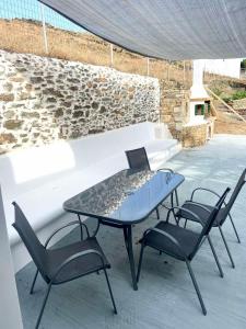 een glazen tafel en 2 stoelen op een patio bij Simousi Studio 1, On the Beach! Kythnos in Kithnos