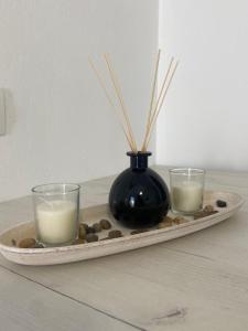 a tray with two candles and a vase on a table at Simousi Studio 1, On the Beach! Kythnos in Kithnos