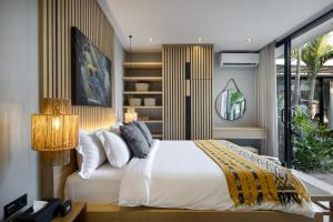 a bedroom with a white bed and a book shelf at Ananda Villa by Betterplace in Jimbaran +12 photos