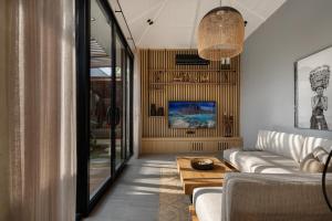 a living room with a couch and a table at Ananda Villa by Hombali in Jimbaran