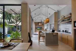 an open kitchen and dining room with a table and chairs at Ananda Villa by Hombali in Jimbaran