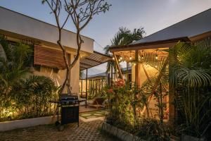 a house with a grill in a courtyard with plants at Ananda Villa by Hombali in Jimbaran