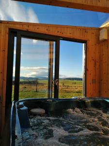 a jacuzzi tub in a room with windows at Knockan in Keith